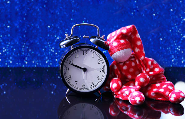 Alarm clock and doll on a blue background, bokeh effect. Twilight, night. The concept of relaxation, rest, sleep. Selective focus, close-up. Alarm clock and doll on a blue background, bokeh effect. Twilight, night. The concept of relaxation, rest, sleep. Selective focus, close-up. кукла stock pictures, royalty-free photos & images