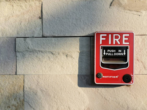istock Manual fire alarm On the white stone tile wall 1129287220