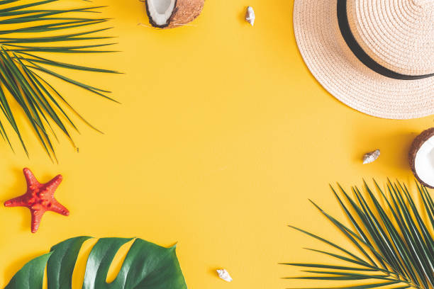 istock Summer composition. Tropical palm leaves, hat, coconut on yellow background. Summer concept. Flat lay, top view, copy space 1129300832