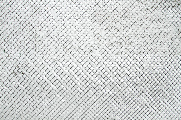 Snow-covered Rabitz grid. Lattice fence covered with fresh snow. Winter background texture. White background texture