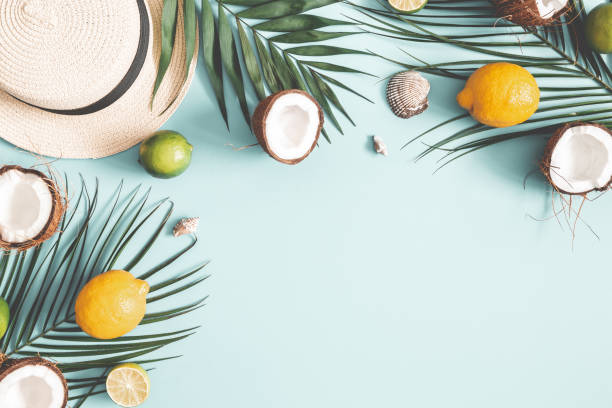 istock Summer composition. Tropical palm leaves, hat, fruits on pastel blue background. Summer concept. Flat lay, top view, copy space 1129301949