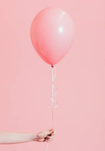 istock Girl with a pink helium balloon 1129305774