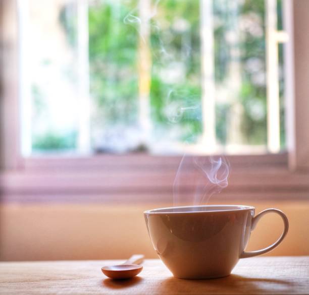 istock a cup of hot coffee steam smoke on wood table 1129309151