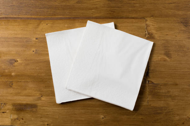 white paper napkin on wooden background white paper napkin on wooden background napkin stock pictures, royalty-free photos & images