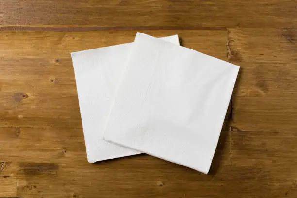 Photo of white paper napkin on wooden background