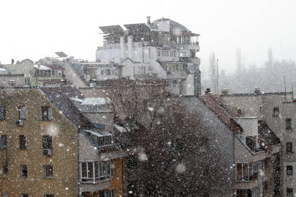 Snow in the city. New snowfall with big snowflakes in the city. Winter snow. Snowflake background texture. Winter wallpaper. Blizzard in midtown. Blurred winter background.