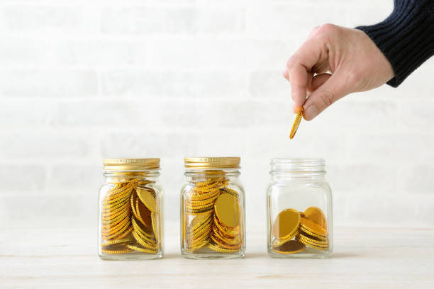istock Business man putting coin in bottle 1129310423