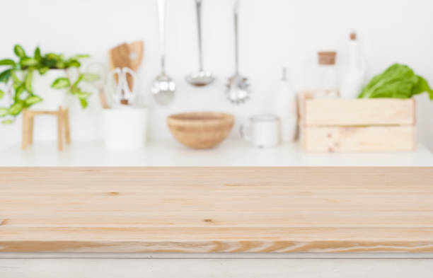 istock Wooden table top over blurred kitchen utensils for product display 1129310439