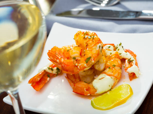 istock Split fried prawns with lemon and parsley on a white plate 1129311121