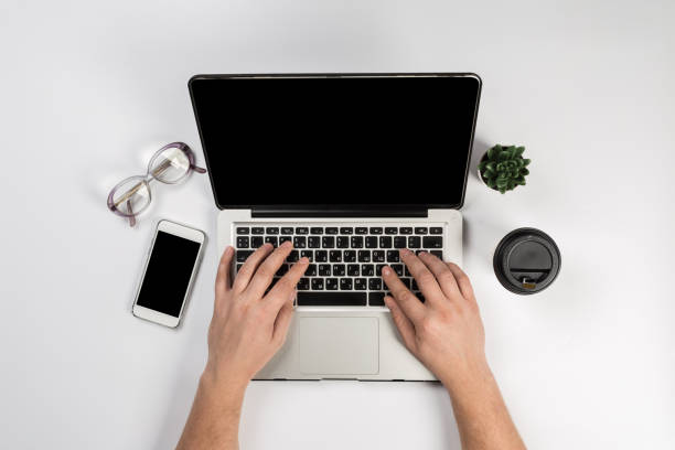 istock Male hands working on modern laptop. Office desktop on white background 1129311601