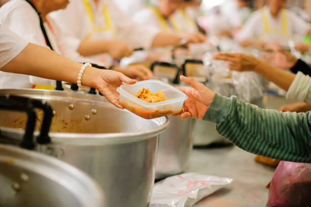 istock Hands holding food: Hunger problems are assisted by people in society. 1129312820
