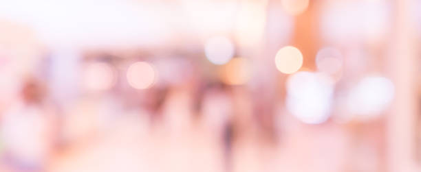 abstract blur inside modern architecture loft cozy interior shopping mall or department store with light bokeh in rose gold tone color for design concept