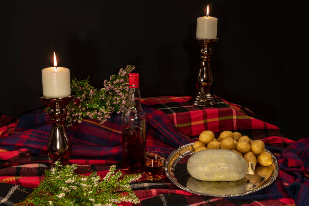 Burns supper table - Sideview Fresh haggis and potatoes on tartan fabrics with heather and candle sticks haggis stock pictures, royalty-free photos & images