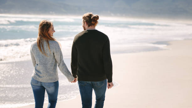 istock Romantic couple walking on the beach 1129317551