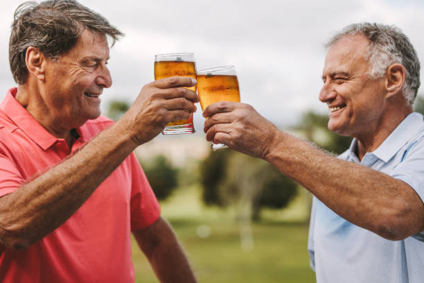 senioren herren feiert mit bier - retirement golfer happiness relaxation stock-fotos und bilder