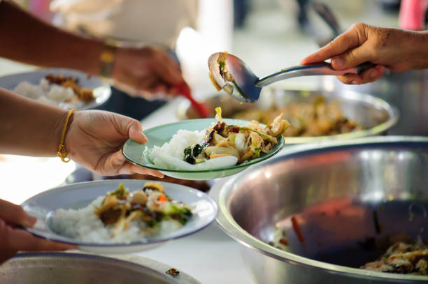 Volunteers serving food for poor people : Food sharing concept Volunteers serving food for poor people : Food sharing concept serving utensil stock pictures, royalty-free photos & images