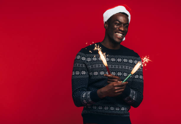 istock Young guy celebrating christmas with fireworks 1129320516