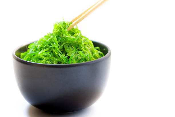hiyashi wakame chuka o algas ensalada en un tazón negro sobre fondo blanco, comida japonesa - wakame salad fotografías e imágenes de stock