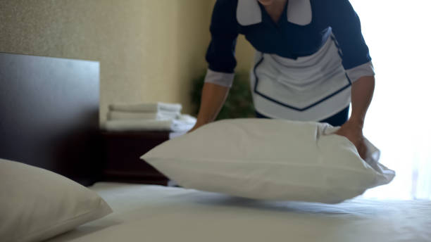 istock Hotel worker plumps pillows after washing bed sheets with fragrant powder 1129321568