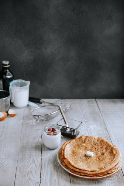 завтрак с тонкими блинчиками и йогуртом на деревянном кухонном столе - domestic kitchen dining table table ingredient стоковые фото и изображения