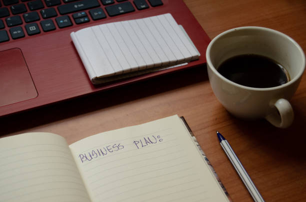 istock home office desk, red laptop, coffee, notebooks, diary, pen 1129323567