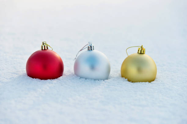 Three Christmas balls on the snow.