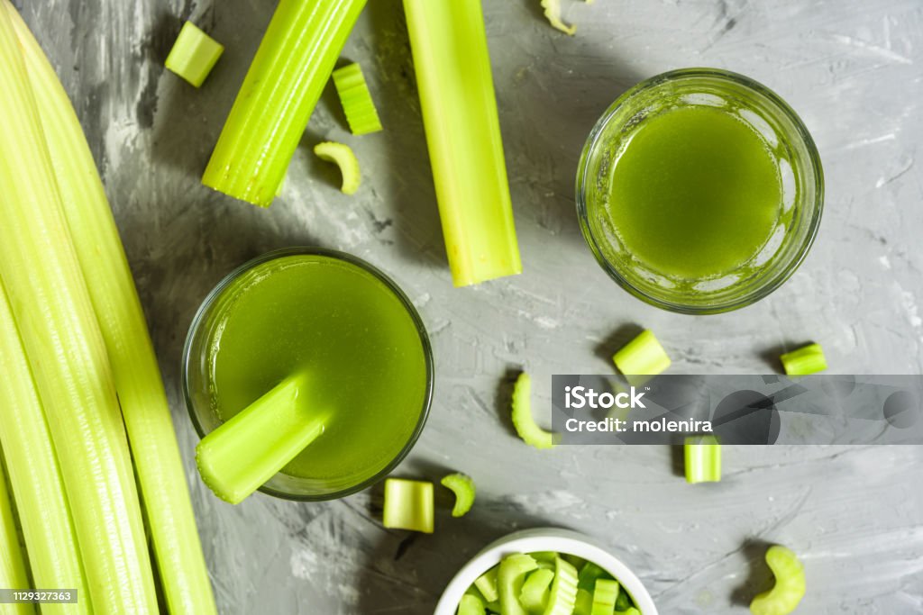 Celery Healthy Green Juice Celery Healthy Green Juice glasses top view on grey background Celery Stock Photo