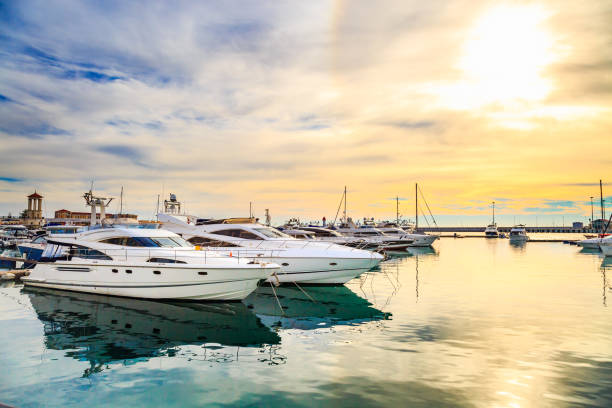 Motor and sailing boats in sunshine. Luxury yachts at sunset. Marine dock of modern motor and sailing boats in sunshine, blue water sea, rainbow with sun. Travel and fashionable vacation. Marina stock pictures, royalty-free photos & images