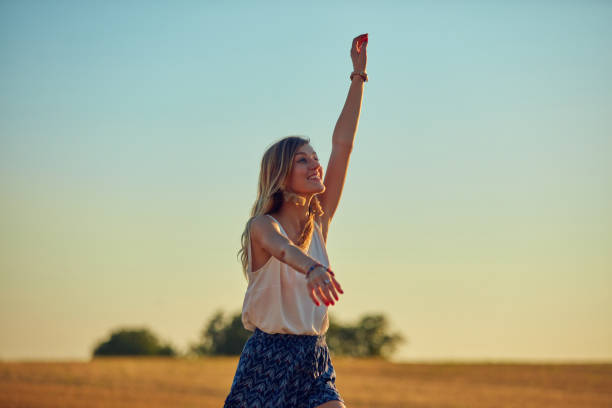 istock Cute young woman jumping in a wheat field. 1129327847