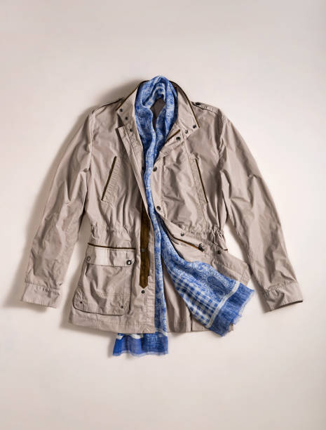 istock Women’s coat with scarf isolated on beige background( 1129328611