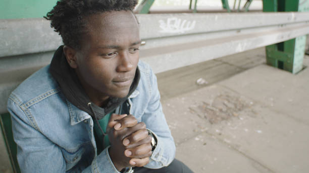istock Lone and despaired young man sitting under bridge 1129328629