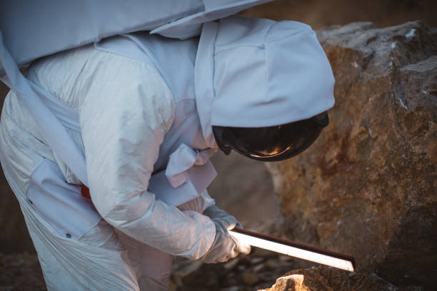 istock Astronaut holding lamp and exploring rock from Mars 1129330156
