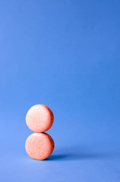 istock Two macaroon coral color imitating the number 8. 1129330836