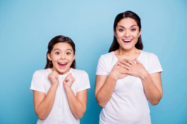 close up photo pretty two people brown haired mum little daughter eyes mouth opened unbelievable arms point herself win lottery prize wearing white t-shirts isolated bright blue background - surprise child little girls shock imagens e fotografias de stock