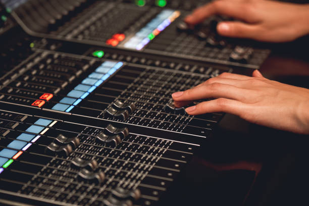 istock Audio system for professionals. Close-up view of sound engineer adjusting digital audio mixing console. Sound recording studio 1129332651