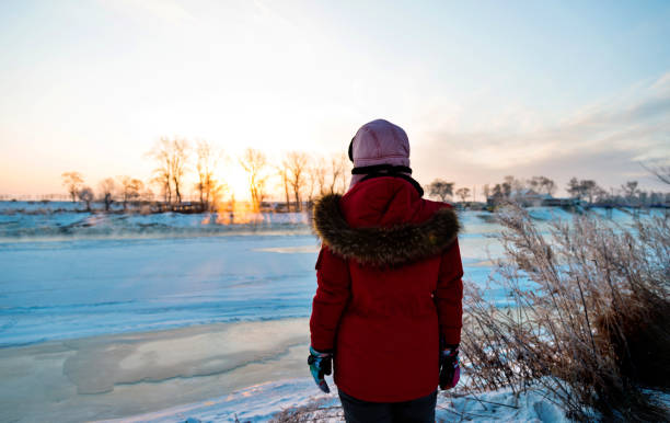 istock Woman standing by the lakeside in winter 1129333068