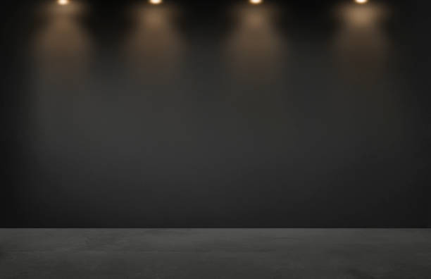 istock Black wall with a row of spotlights in an empty room 1129333409