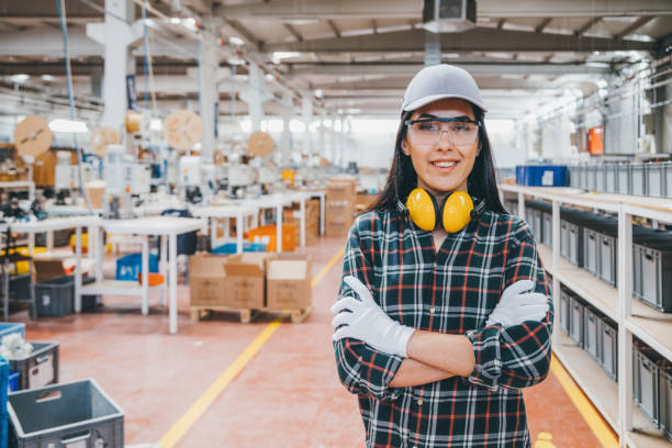 若い女性の産業工場の肉体労働者の肖像 - helmet stack safety hardhat ストックフォトと画像