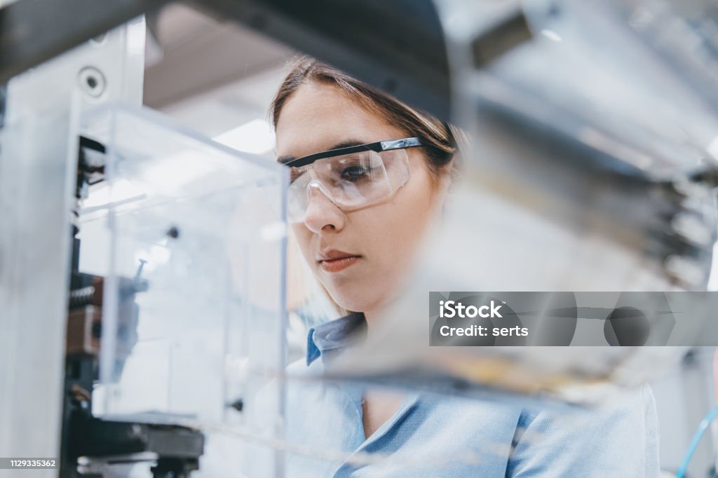 製造工場での装置の操作女性の産業労働者 - 実験室のロイヤリティフリーストックフォト