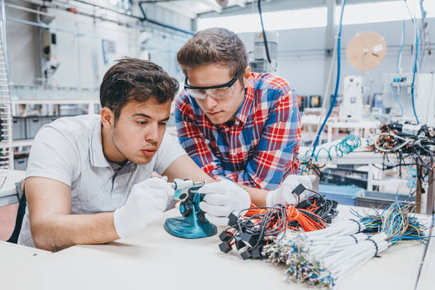 istock Young industry employees men working with manufacturing equipment 1129335617