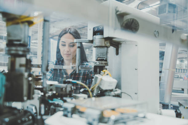istock Female technician working with manufacturing equipment in a factory 1129335826