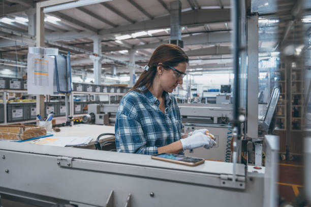 istock Female technician working with manufacturing equipment in a factory 1129335831