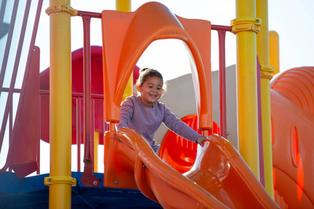 istock A girl slides on a slide. 1129336913