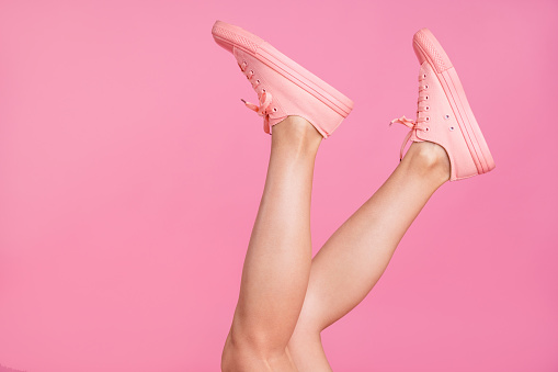 Cropped image view photo of nice attractive feminine girlish fit slim clear shaven legs active sport walk go steps trendy fasionable foot-wear isolated over pink pastel background