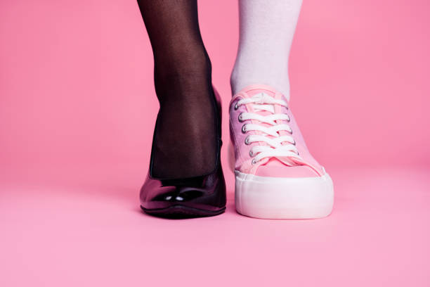 coupées en gros plan image concept photo de deux fit différentes minces minces jambes confortables chaussures de luxe élégant comparaison sportive chic confort luxe isolé sur fond pastel rose - alternative culture photos et images de collection