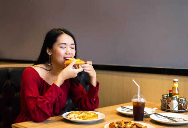 istock Girl eating pizza in the restaurant 1129341741
