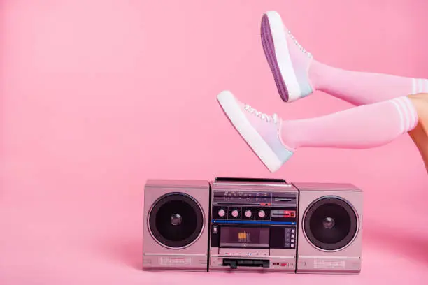 Photo of Cropped close up photo skinny perfect ideal she her lady legs raised up lying near boom box playing fitness training workout press swing happy soundtrack turned on isolated pink rose background