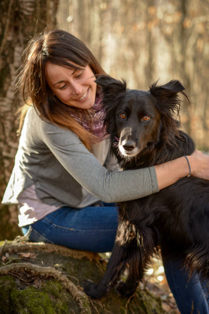 istock Woman with dog in the forest 1129341771