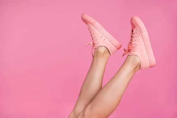 Photo of Cropped close-up image view photo of nice attractive feminine fit thin slim shaven legs active sport walk go steps trendy foot-wear isolated over pink pastel background