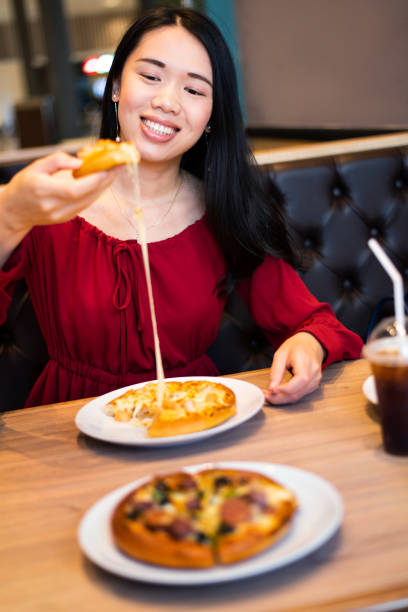istock Girl eating pizza in the restaurant 1129341841